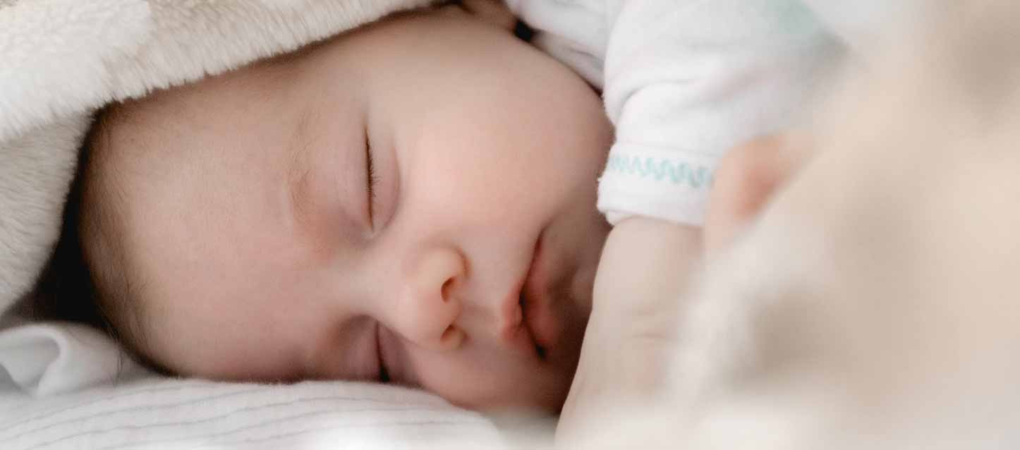 bebé durmiendo en colchón tapado