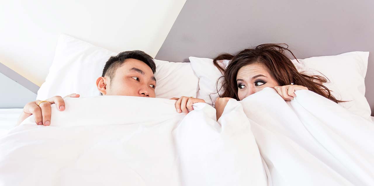 pareja mirándose en las sábanas