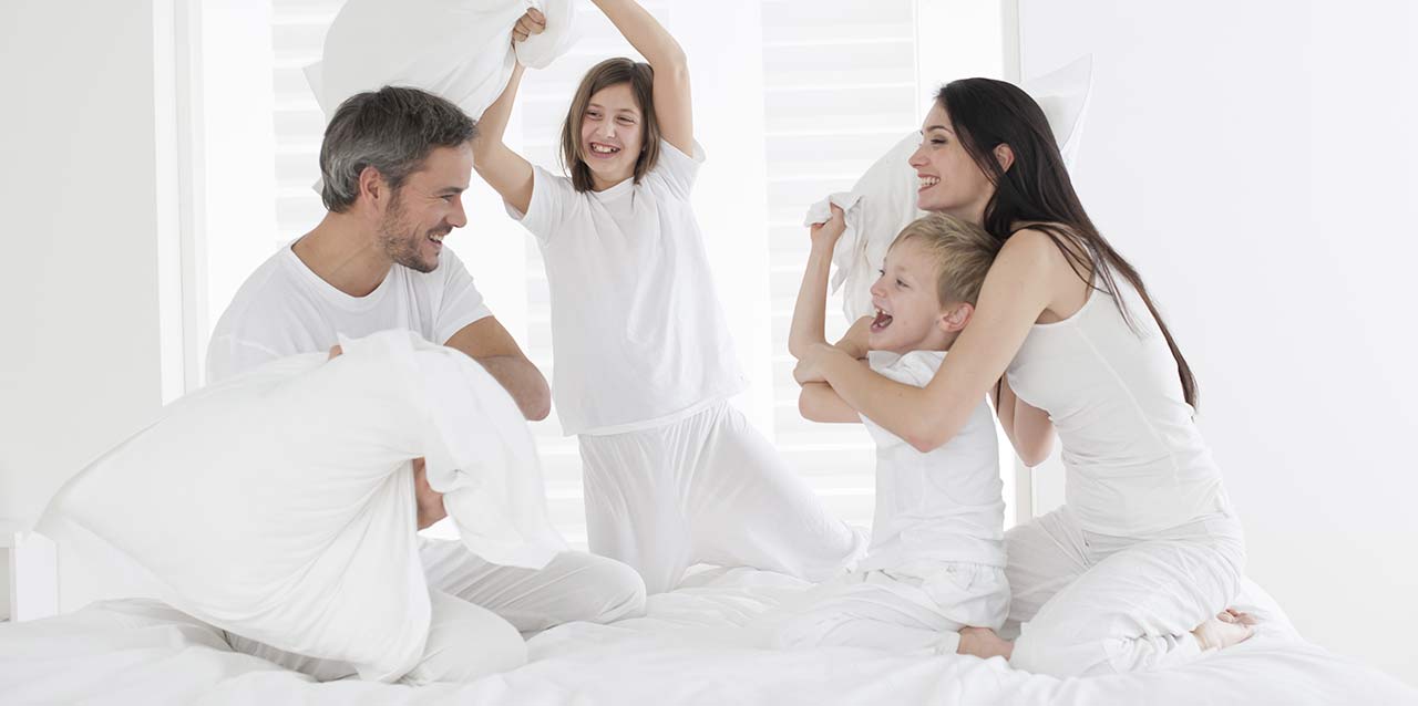familia haciendo guerra de almohadas
