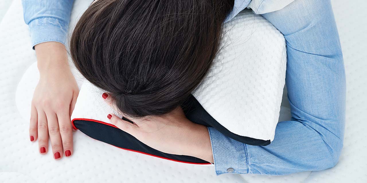 mujer tumbada boca abajo en almohada viscoelástica