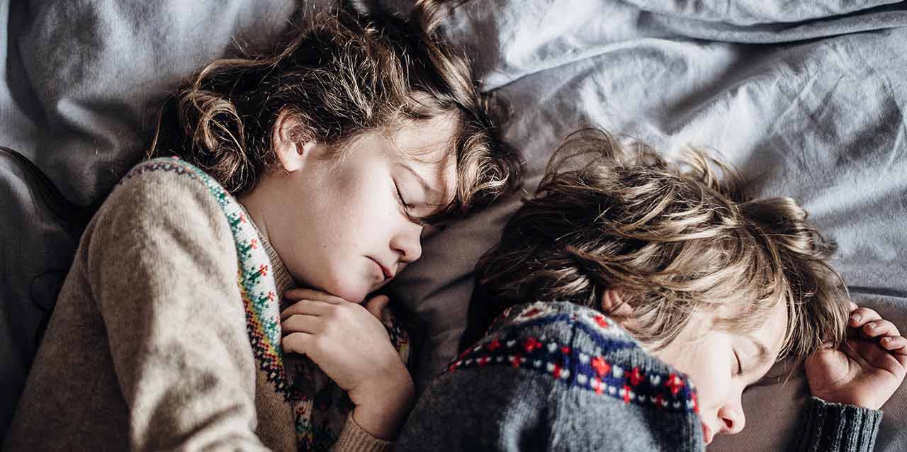 niños durmiendo de lado abrazándose