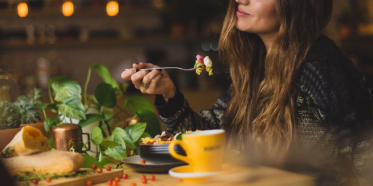 chica comiendo ensalada de pasta