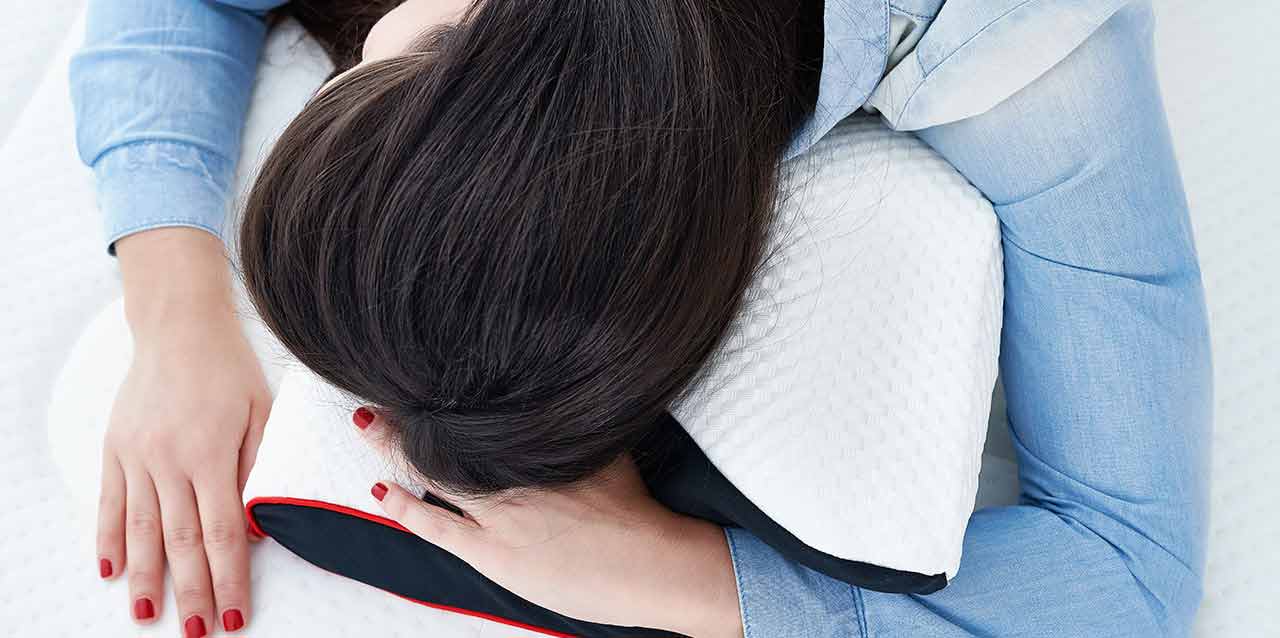 mujer durmiendo en almohada cervical