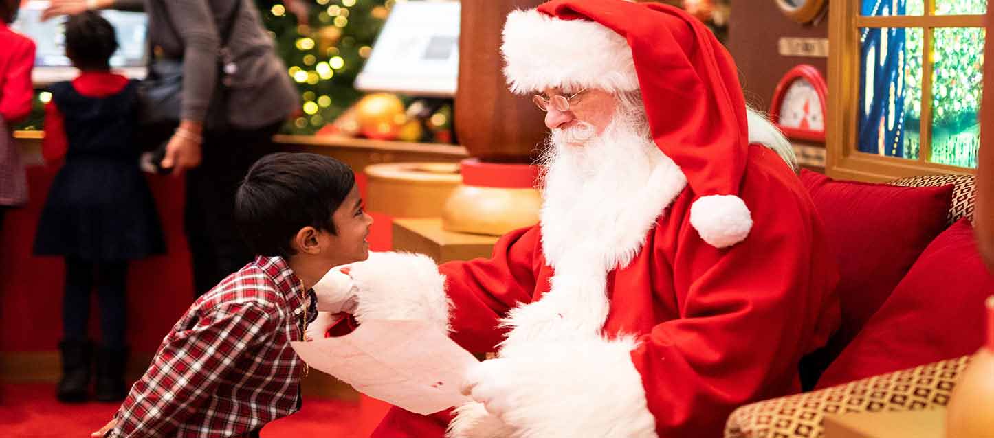 niño con camisa a cuadros con papa noel