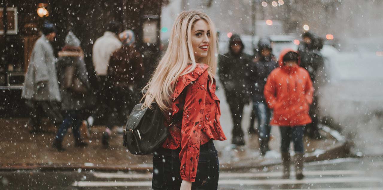 mujer con camisa roja en calle nevando