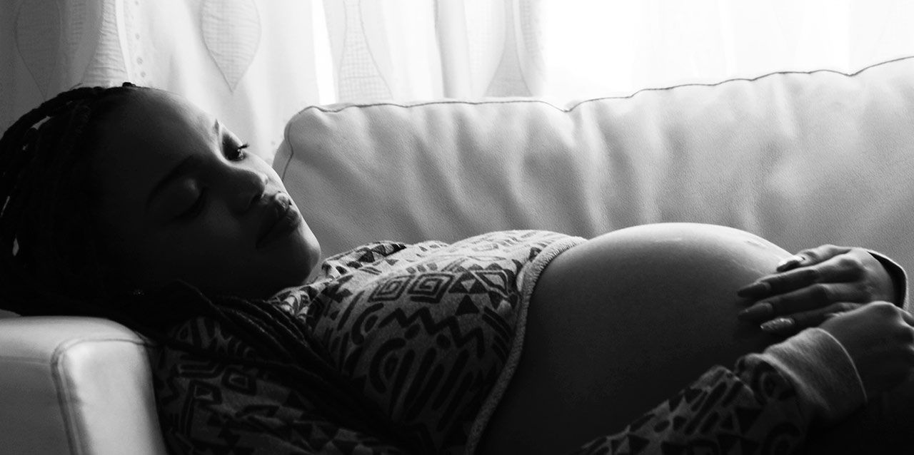 mujer embarazada tumbada en sofá