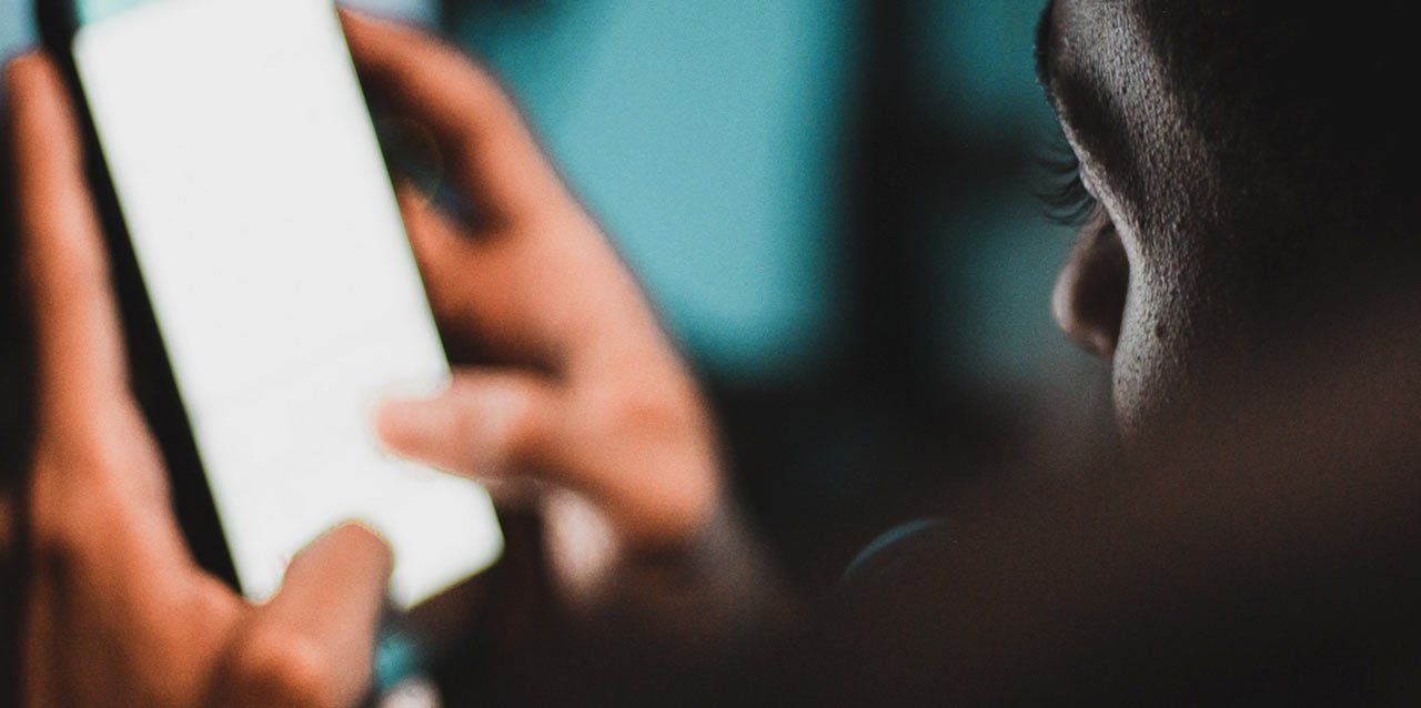 hombre manipulando smartphone de noche
