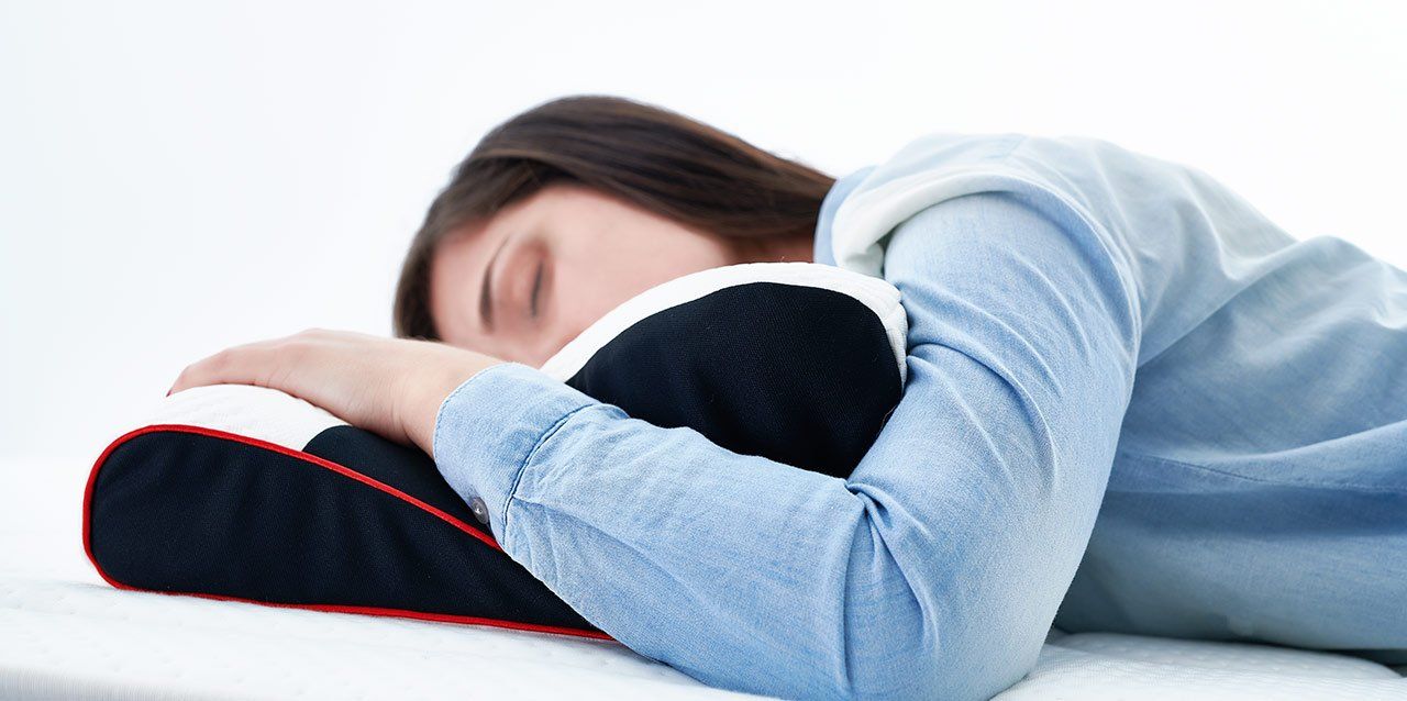 que-beneficios-aporta-una-almohada-ergonomica-1 mujer tumbada de lado en almohada viscoelástica