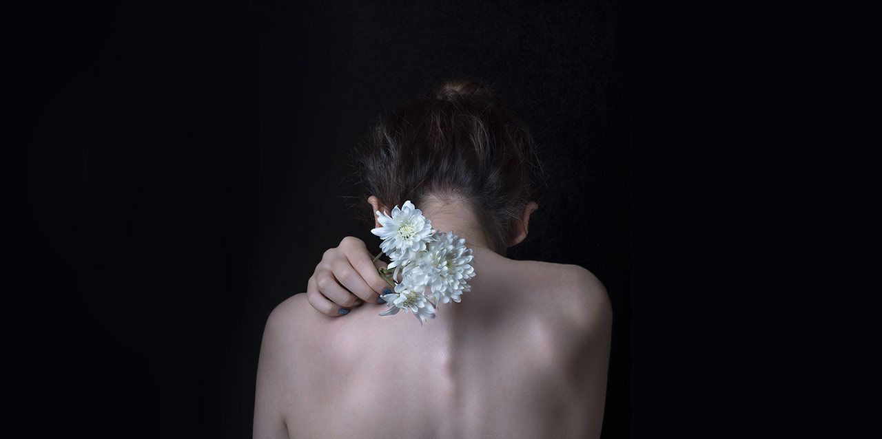 mujer con ramo de flores en la espalda