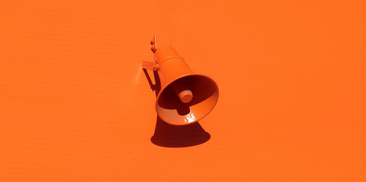 altavoz naranja en pared