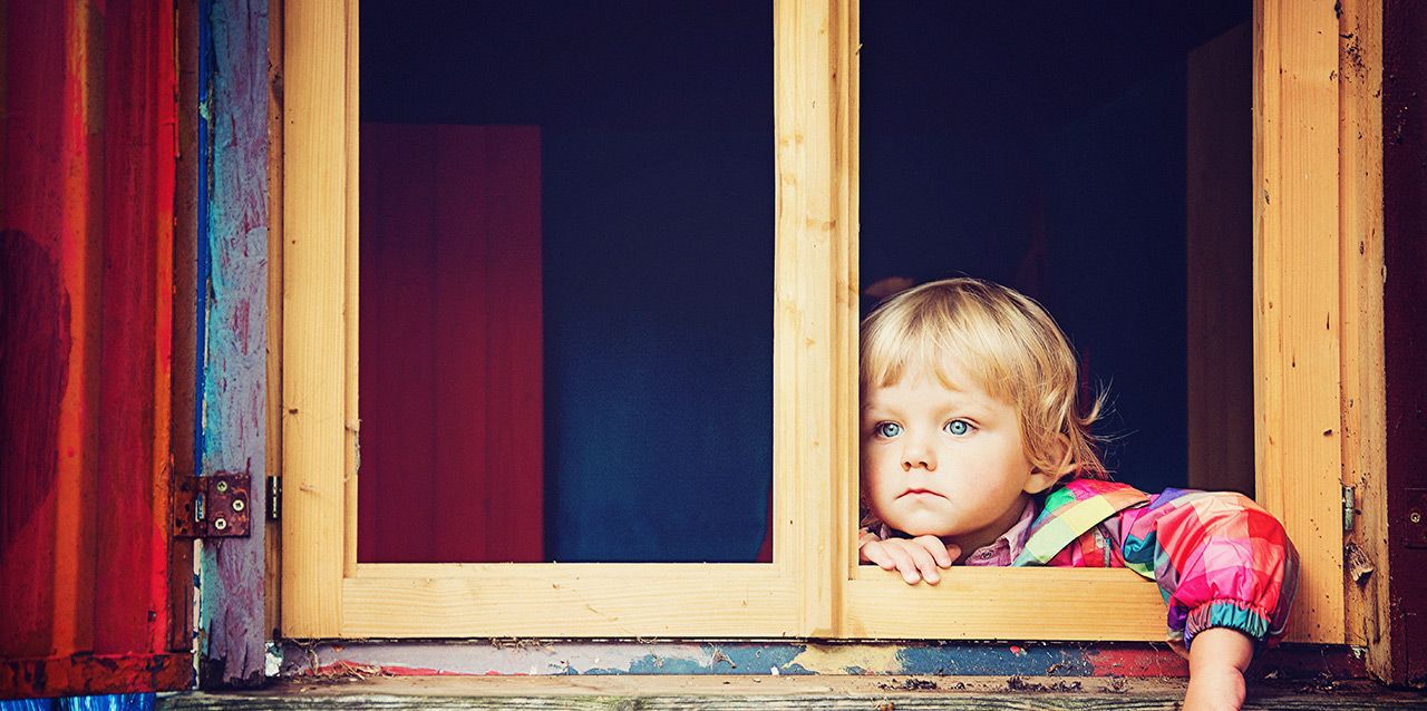 niño serio miranddo por la ventana
