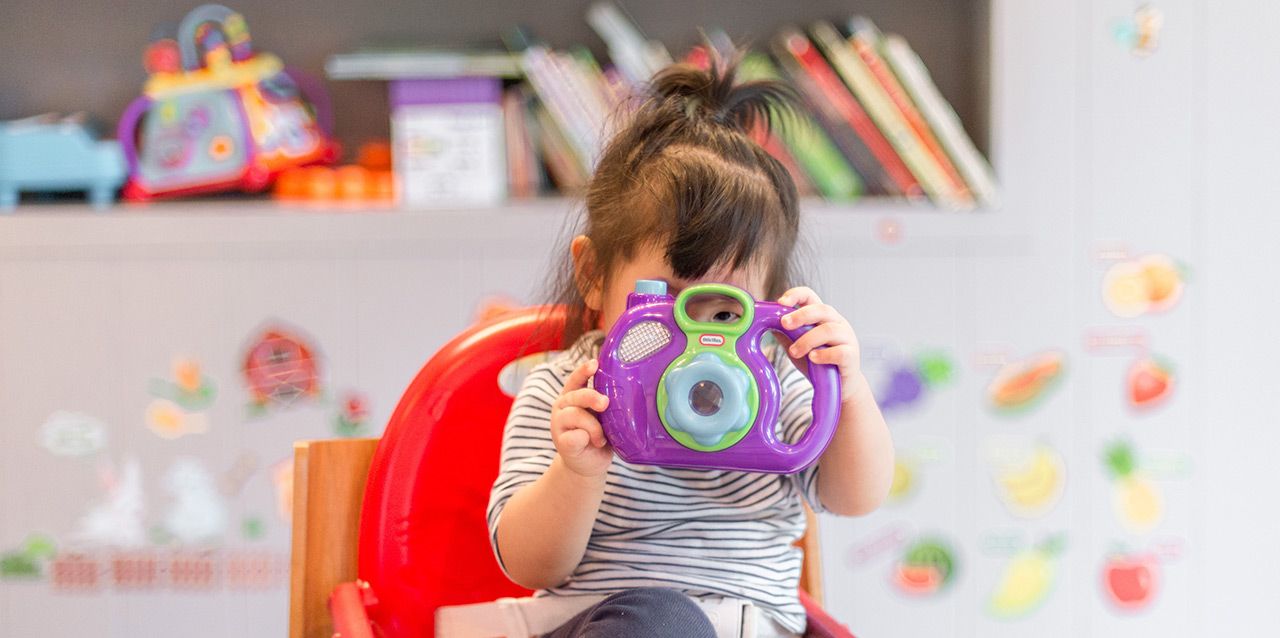 niña con cámara de fotos de juguetes