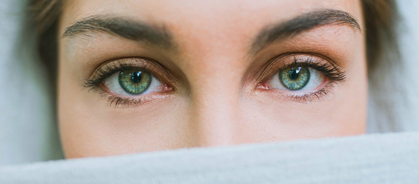 chica de ojos verdes tapada con una sabana hasta la nariz y con tic en el ojo