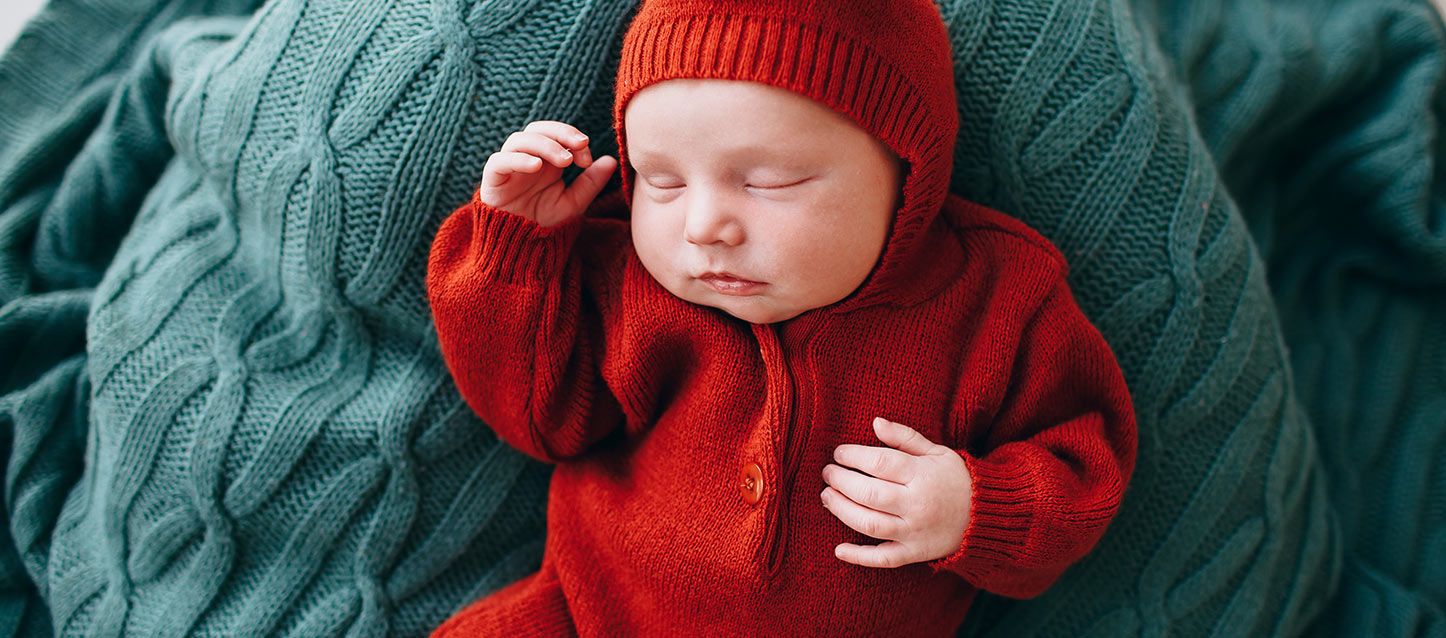 bebe durmiendo boca arriba con pijama rojo