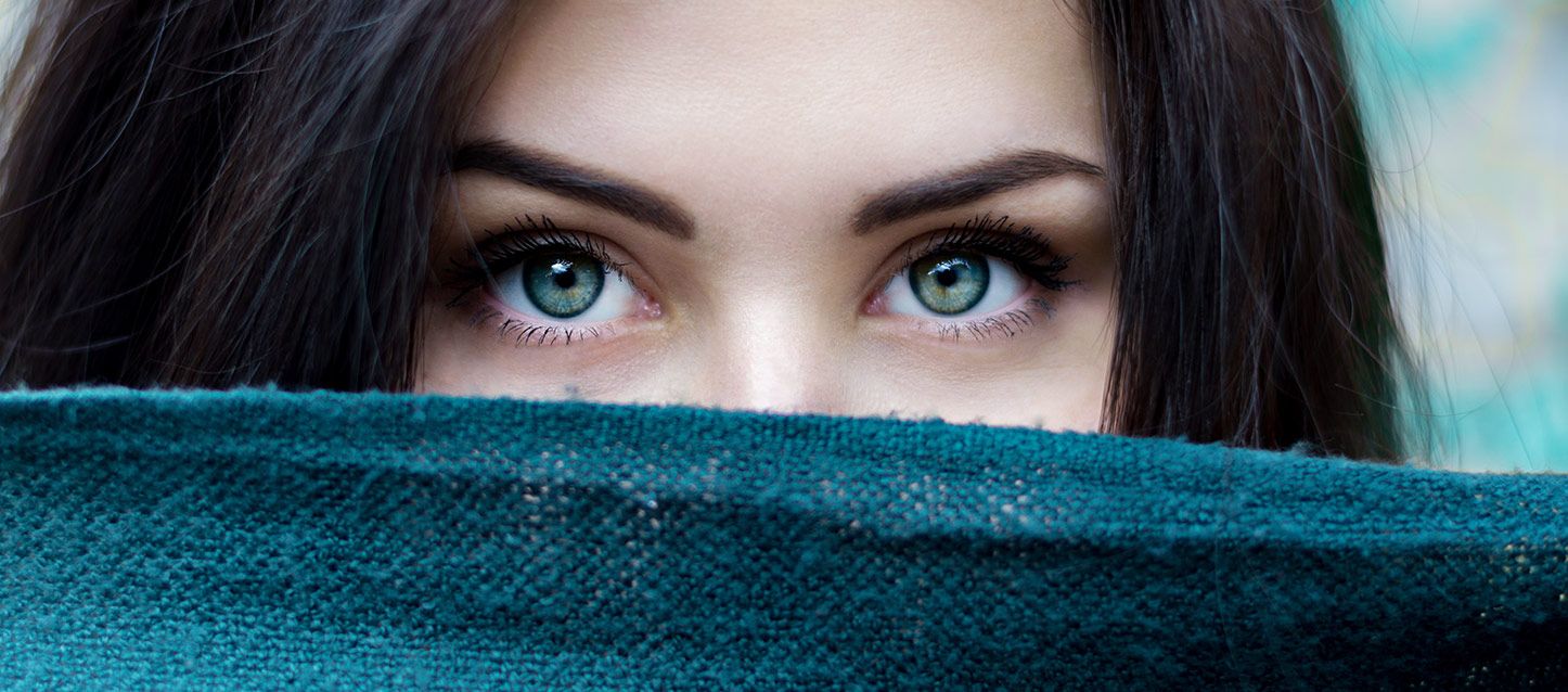 chica de pelo largo moreno y ojos azules verdoso tapada con una bufanda extendida