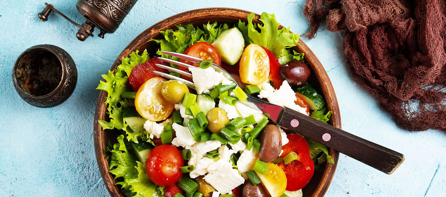 bol con cena ligera con ensalada, queso fresco, cherries, judias verdes y aceitunas