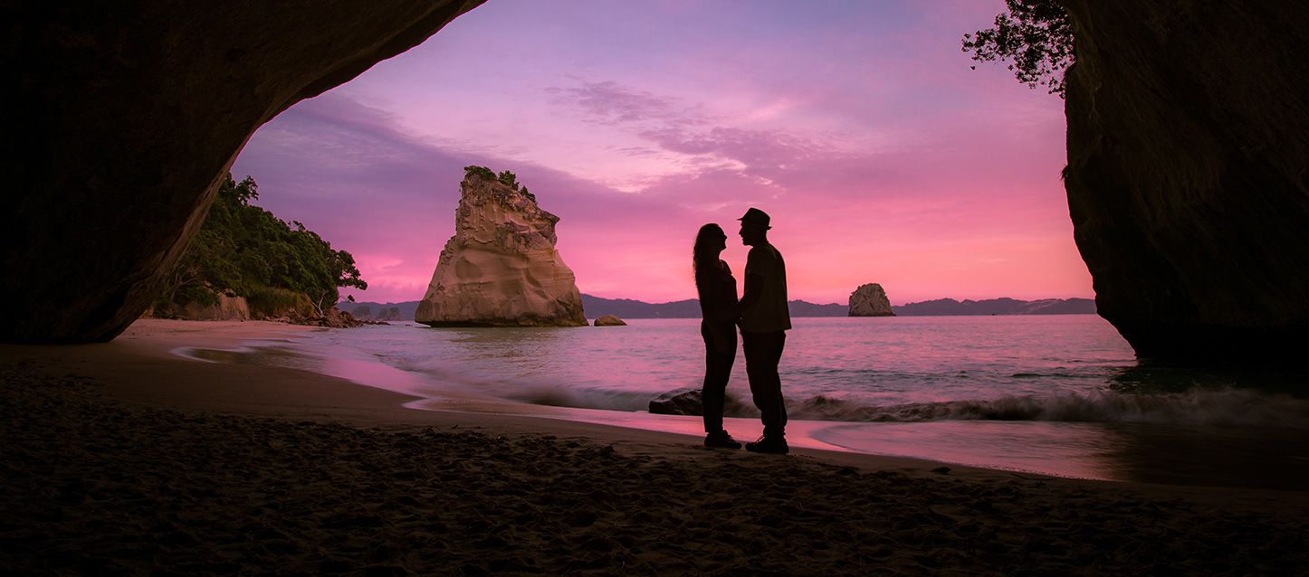 una mujer y un hombre uno frente al otro en un cala paradisíaca