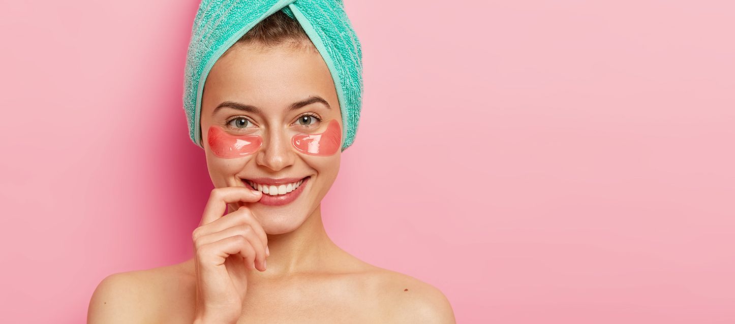 chica con toalla enrollada en la cabeza con tratamiento antibolsas en los ojos
