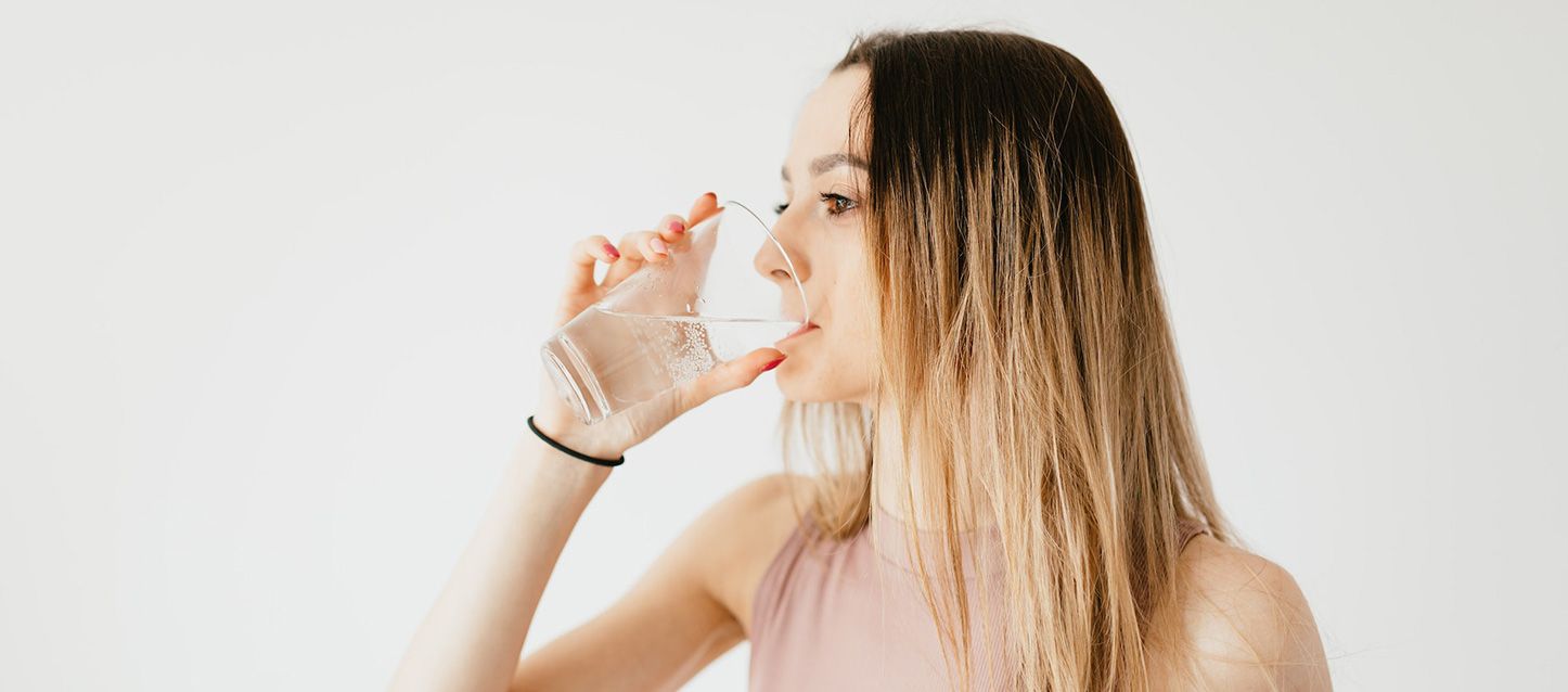 Una chica bebiendo un vaso de agua